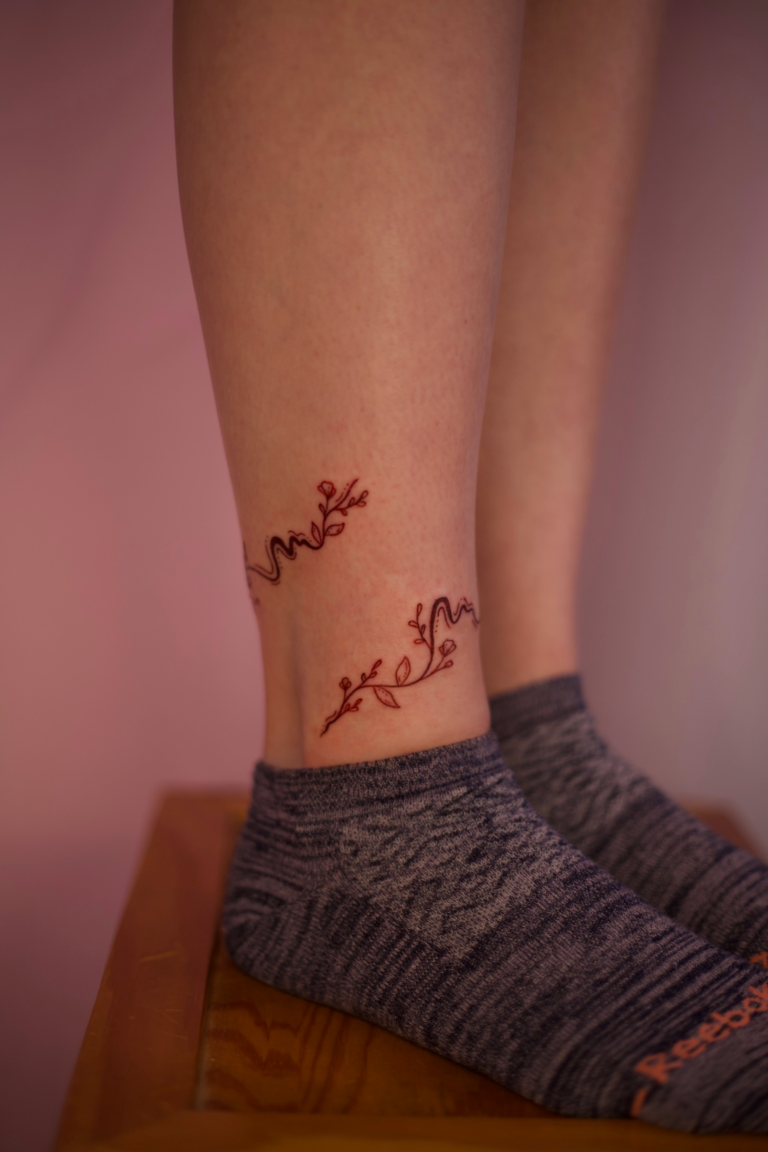 Swirly Ankle Wrap Tattoo With Flowers