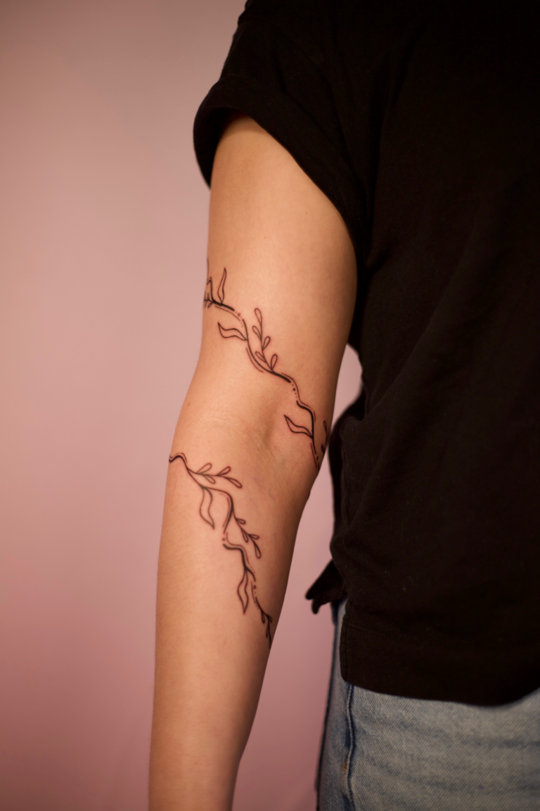 Swirly Arm Wrap Tattoo With Leaves and Vines